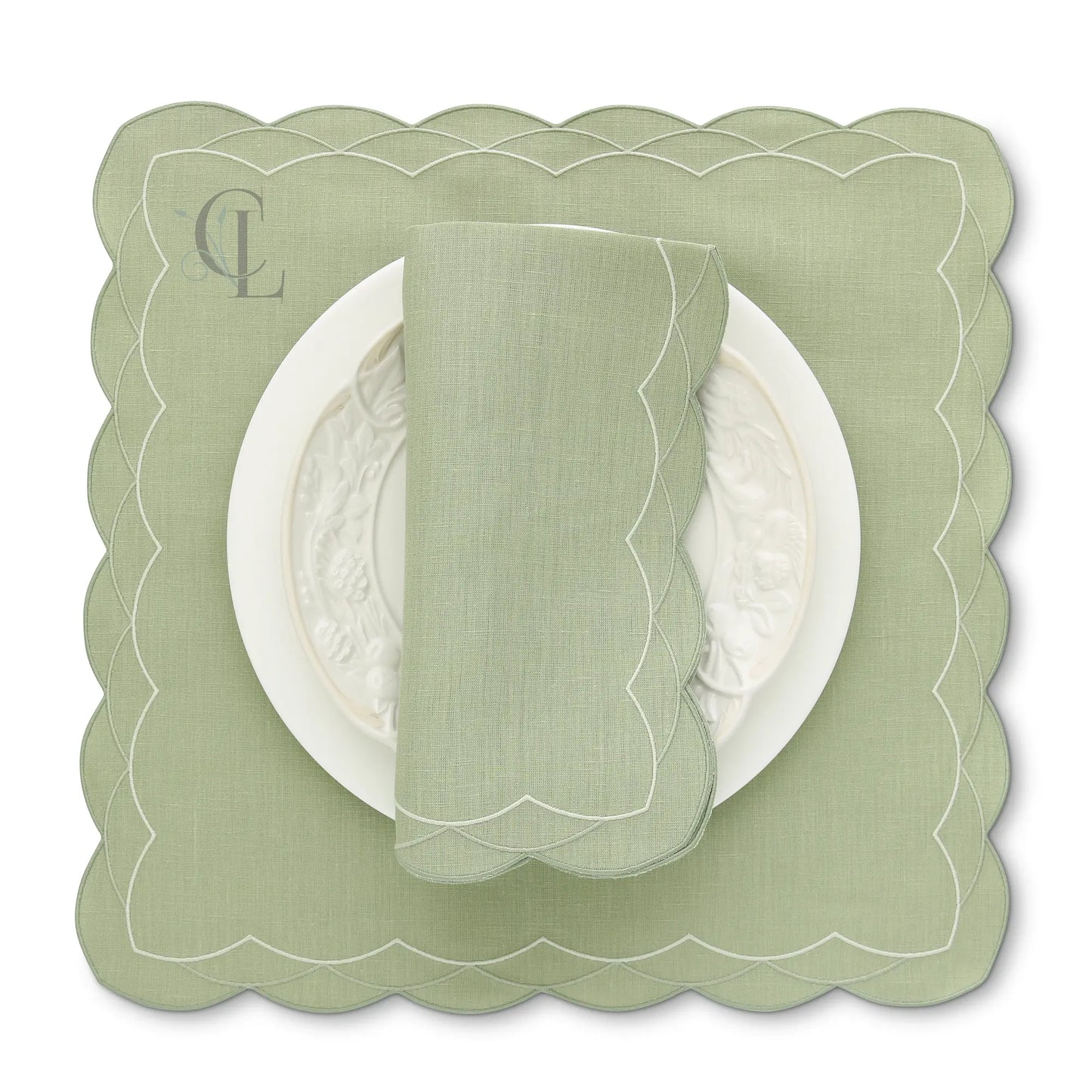 Green scalloped Cosmo placemat with a matching napkin on a white background