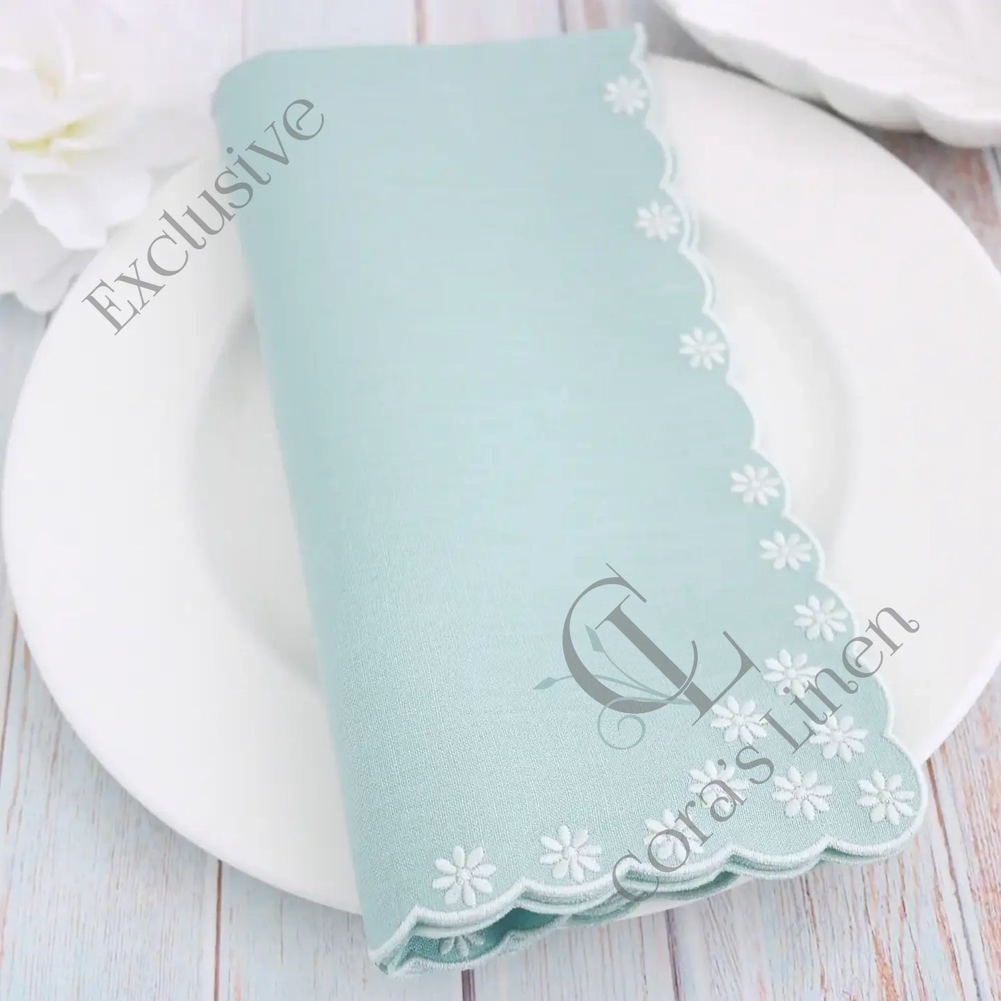 Harbor Green embroidered napkin with floral patterns on a white plate