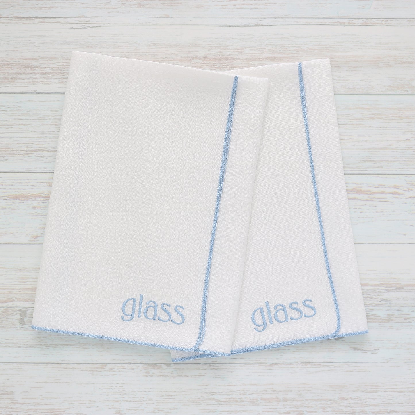 White linen polishing kitchen towel, in style "Merrow" with Baby Blue trim, set of two, with word "glass" stitched on the bottom corner, handmade by Cora's Linen