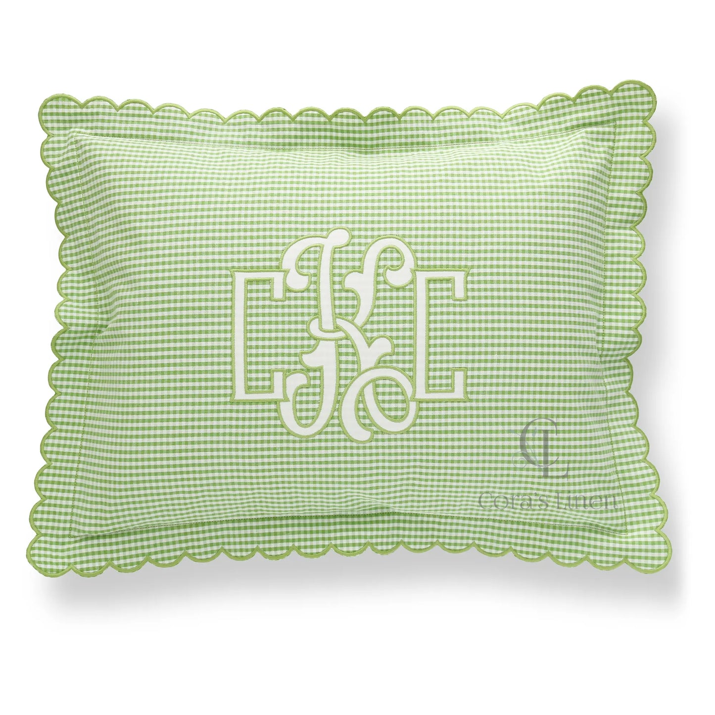 Green and white seersucker scalloped boudoir sham with monogram CKC in White on the front, placed on a marble surface.