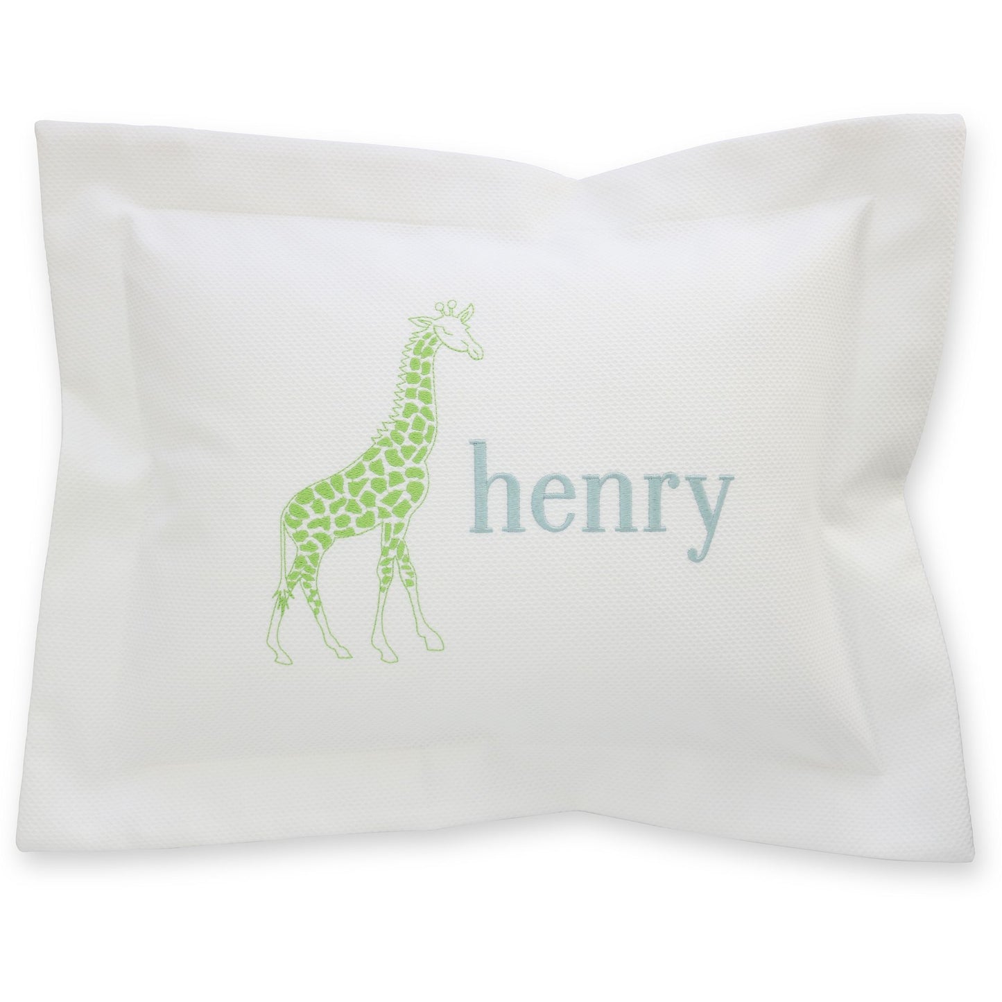 A white pique baby pillow with a green giraffe and the name 'henry' monogrammed on it.