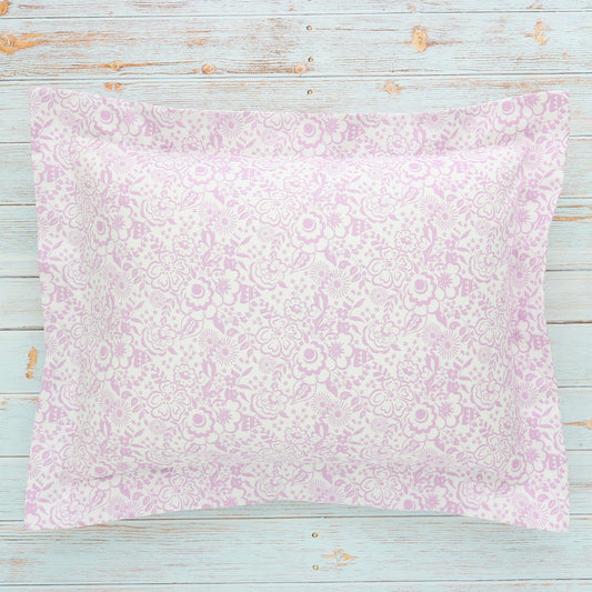 A boudoir sham with a small floral Liberty London print in violet and white, displayed on a wooden surface.