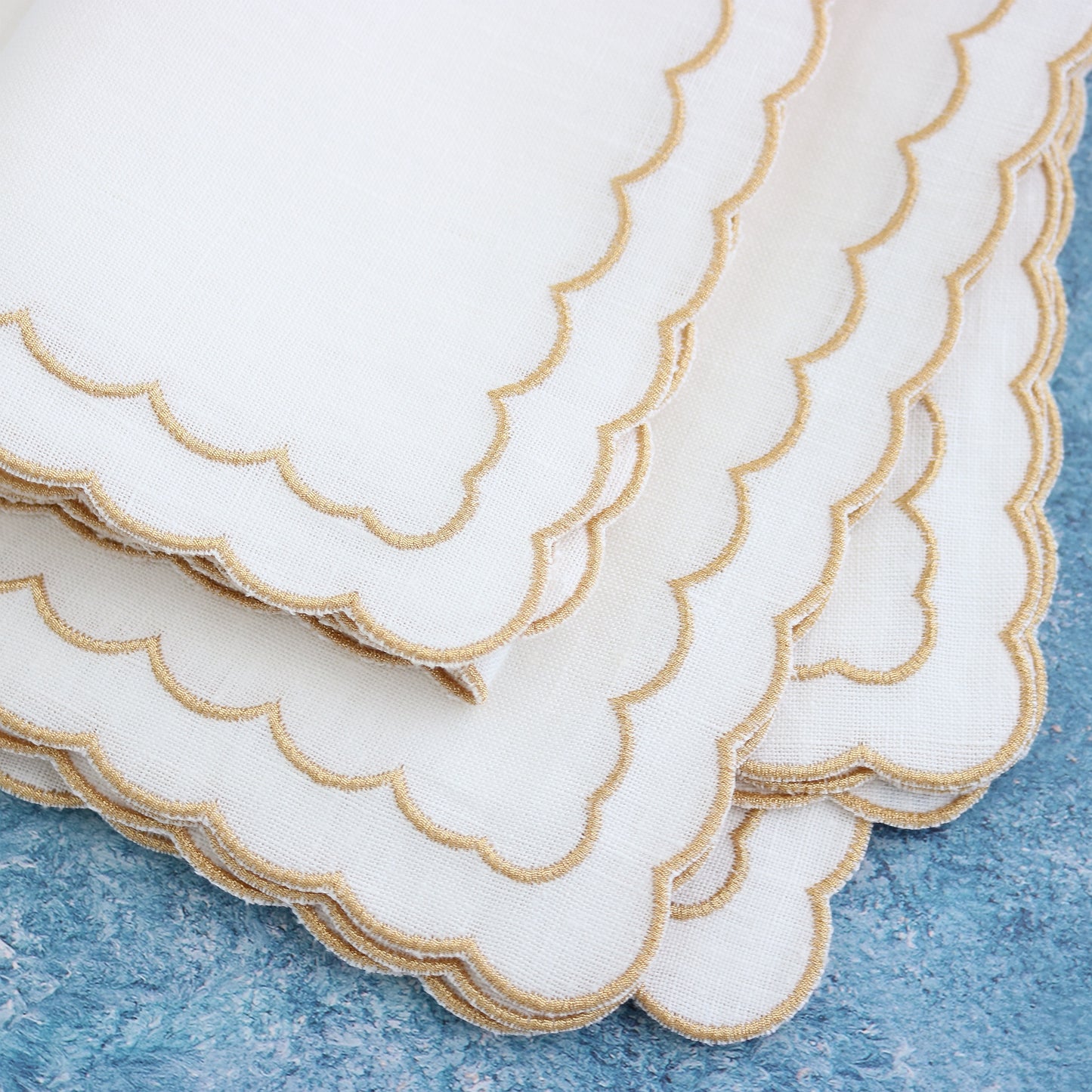 cloese-up of white napkins with gold metallic scallops