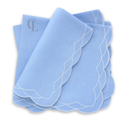 Set of Cosmo bluebell napkins with white scalloped edges on a white background, featuring the brand 'Cora's Linen'.