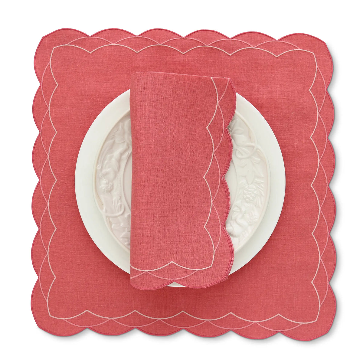 Lobster Red scalloped Cosmo placemat with a matching napkin on a white background