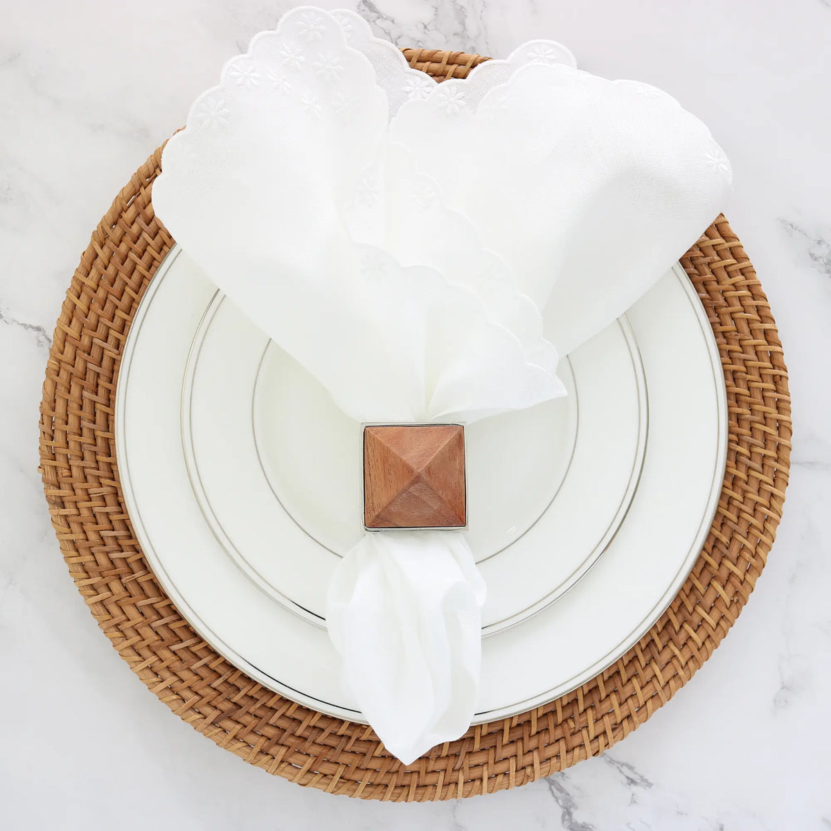 Place setting with a white "daisies" linen dinner napkin by Cora's Linen