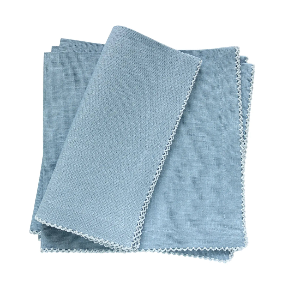 A stack of 4 Denim blue linen napkins with Poplin pale blue picot trim, neatly folded