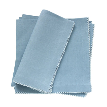 A stack of 4 Denim blue linen napkins with Poplin pale blue picot trim, neatly folded