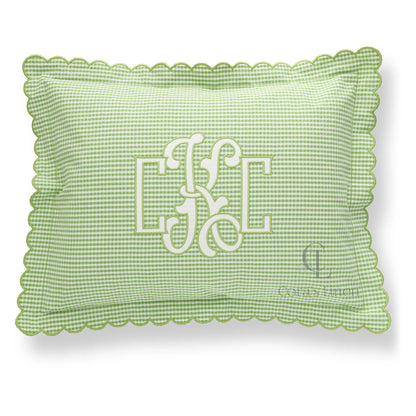 Green and white seersucker scalloped boudoir sham with monogram CKC in White on the front, placed on a marble surface.