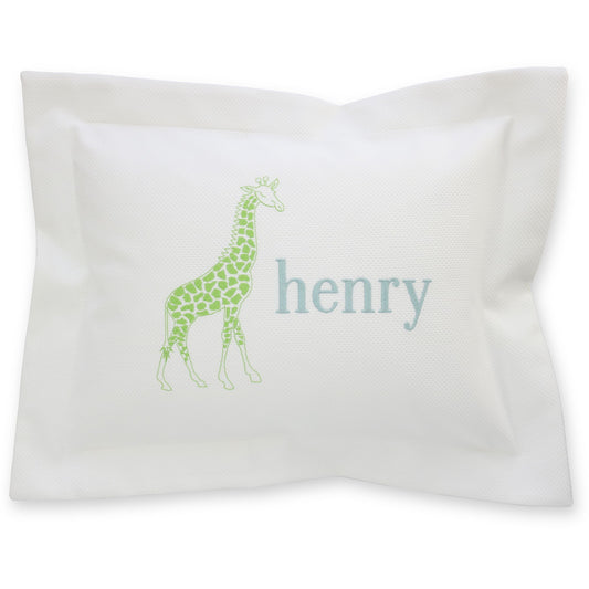 A white pique baby pillow with a green giraffe and the name 'henry' monogrammed on it.