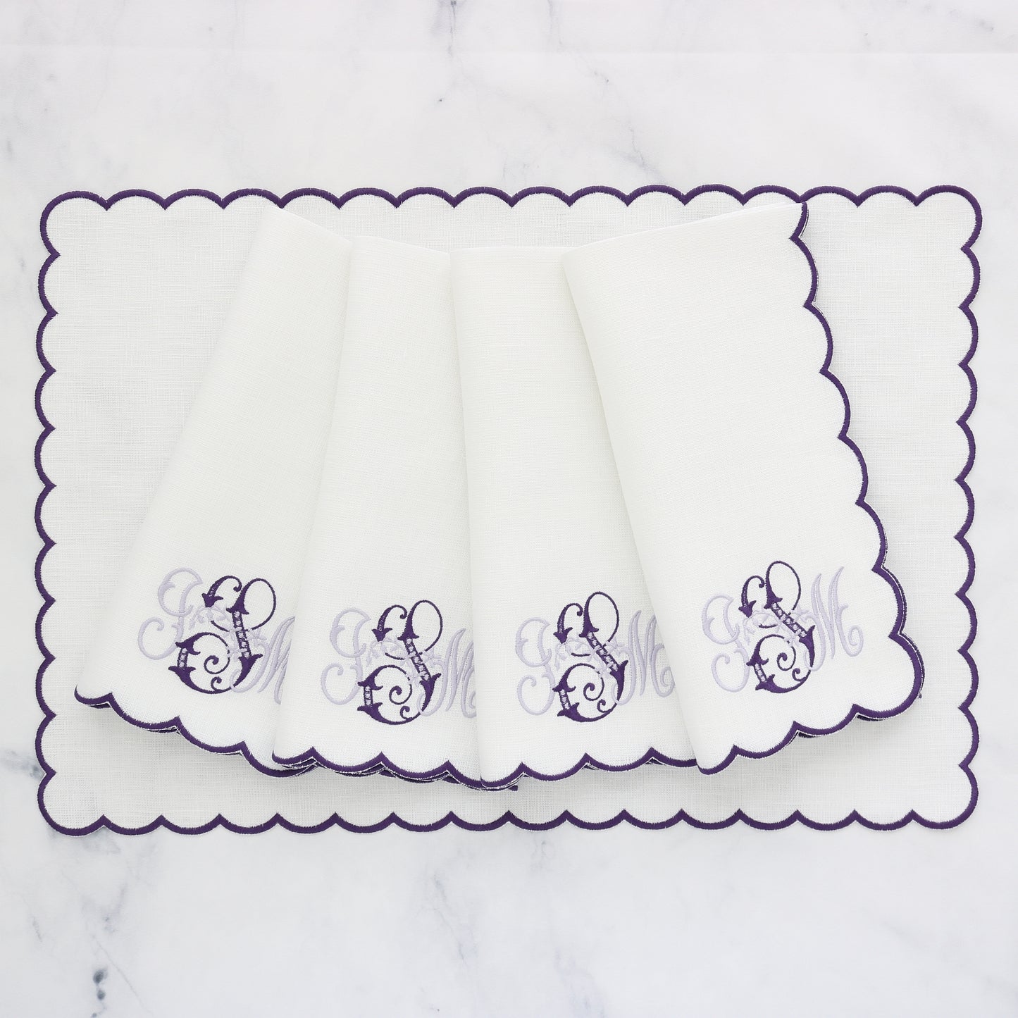 set of 4 white napkins with purple scallops and monogram ISM on a matching rectangular placemat