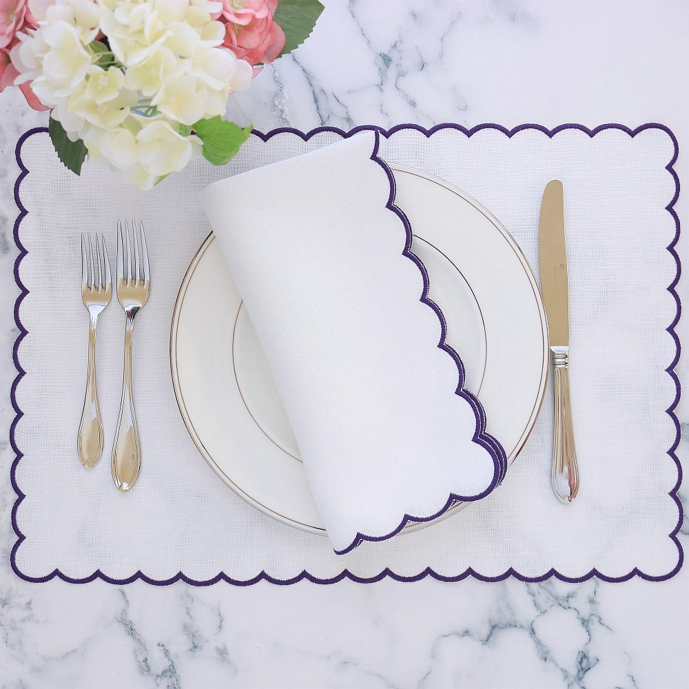 table setting with white napkin with purple scallop and matching placemat