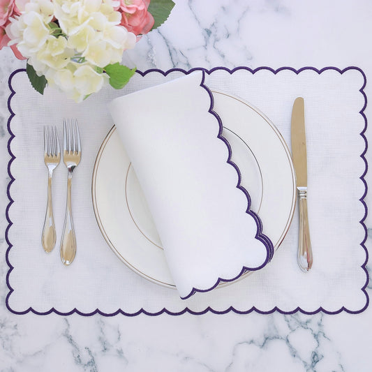 table setting with white napkin with purple scallop and matching placemat
